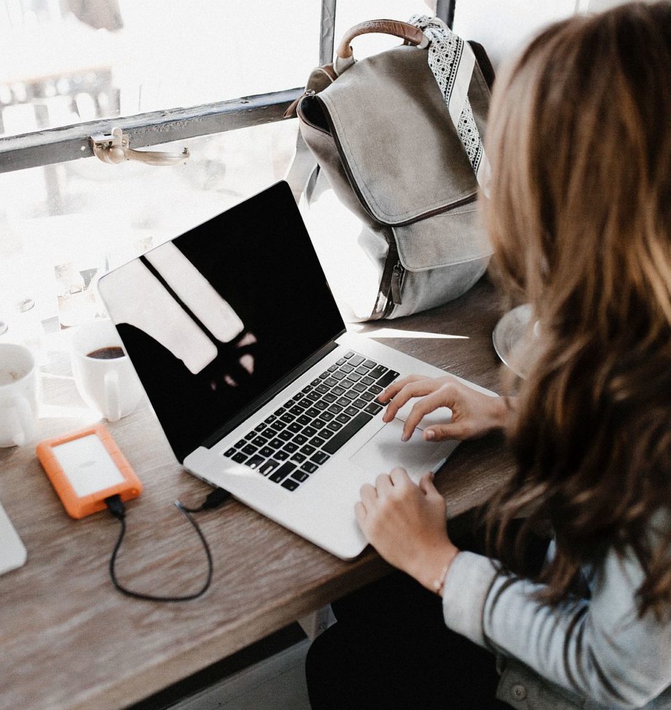 A woman with her hands at a keyboard, showing how to write a great blog post.